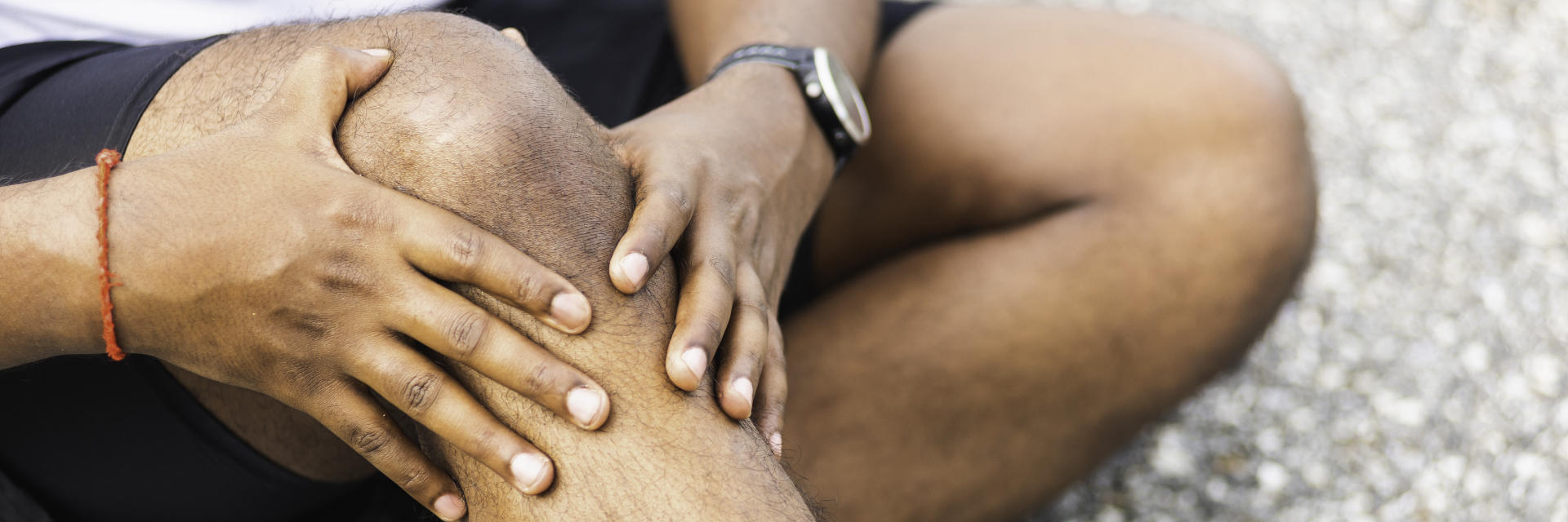 An injured sportsman touching the painful knee area.