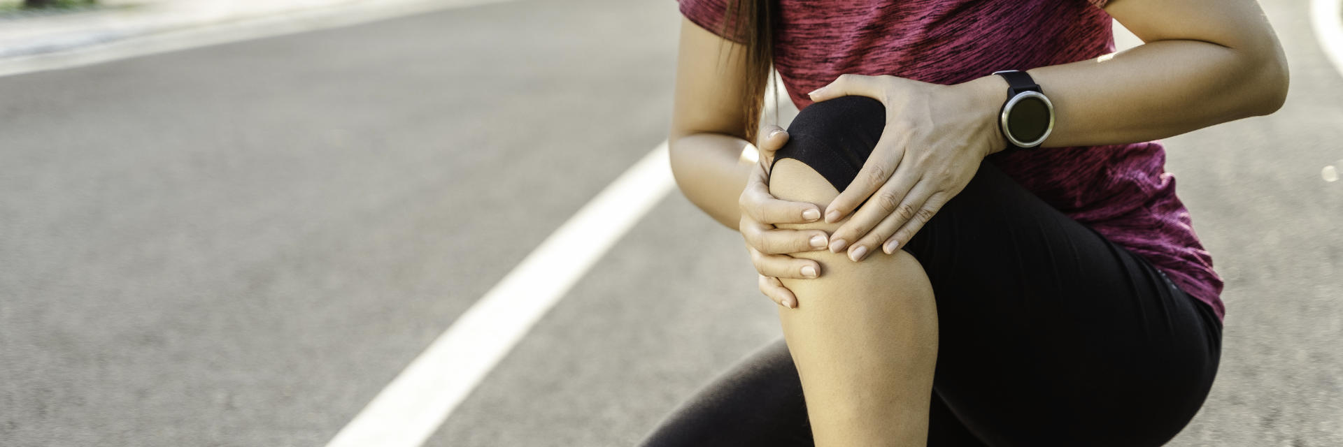 A running woman stopped by knee pain.