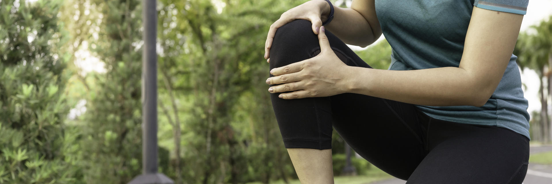 A sportswoman touching the painful knee area.