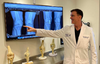 Dr. Buechel presenting pre and post-operative x-rays of his knee replacement patient.