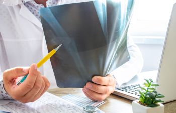 An orthopedic doctor during a consultation looking at an X-ray.