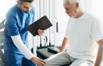 A senior man with knee pain during a doctor's appointment.